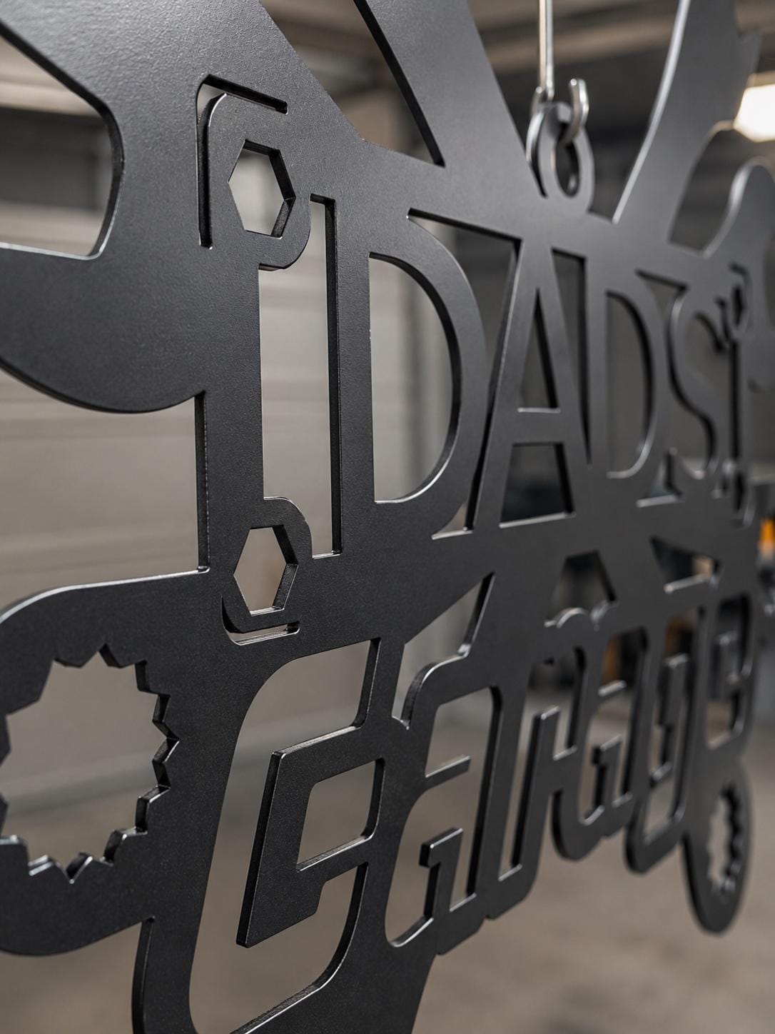 Metallic decorative wall art with cut-out letters and shapes.