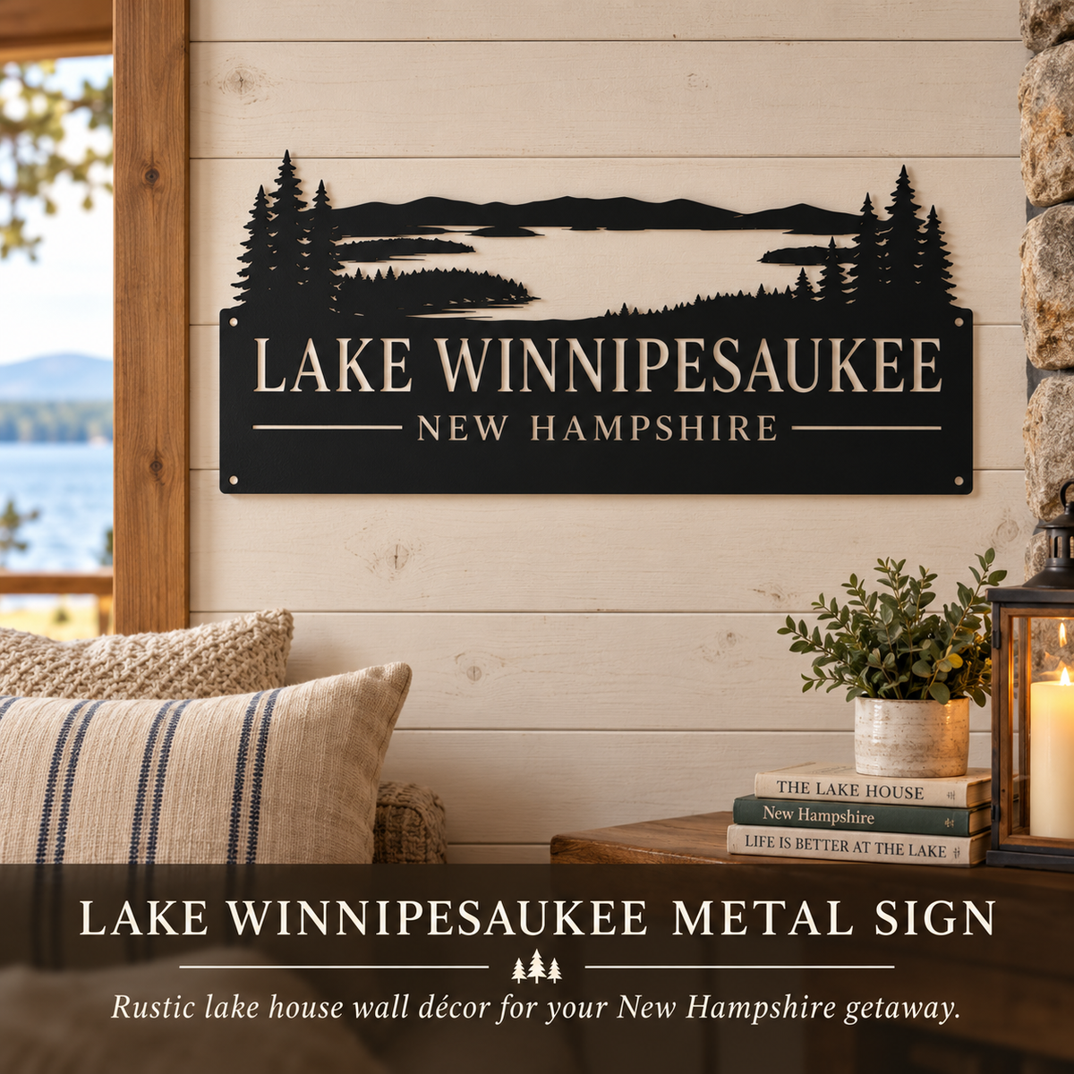Black metal wall sign featuring a laser-cut lake and forest landscape with the text 'LAKE WINNIPESAUKEE' and 'NEW HAMPSHIRE', displayed on a light wood shiplap wall in a rustic porch setting with pillows, books, and a lantern.