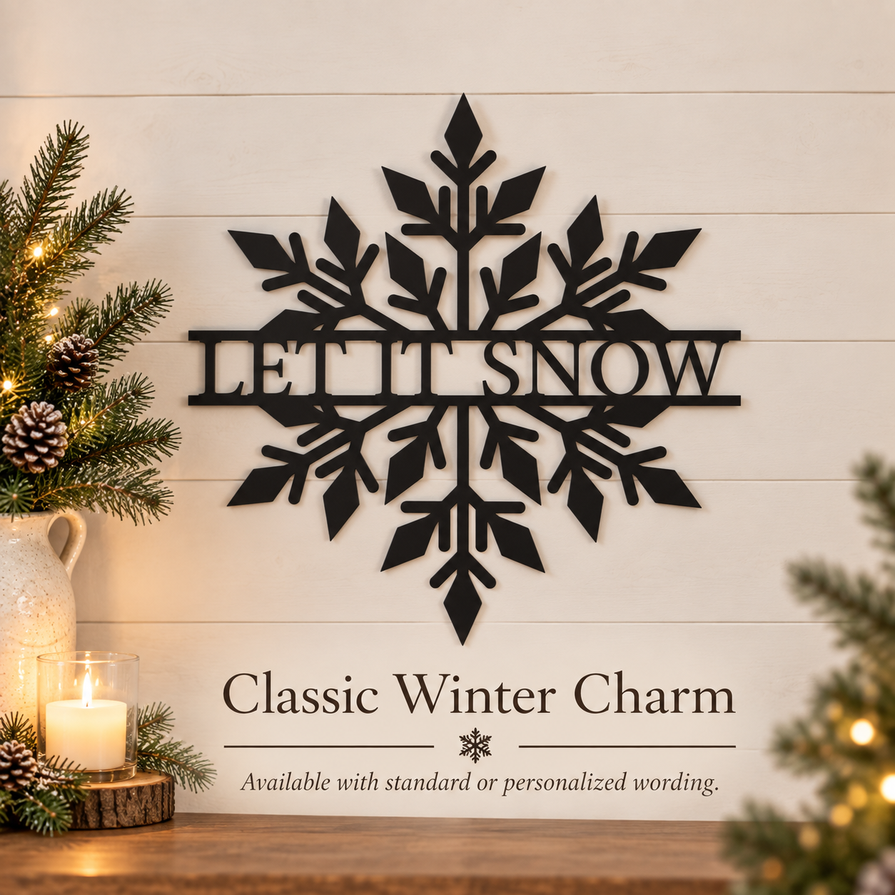 Black metal snowflake wall decor with the words 'LET IT SNOW' in the center, displayed on a white shiplap wall above a wooden surface with candles and evergreen branches.